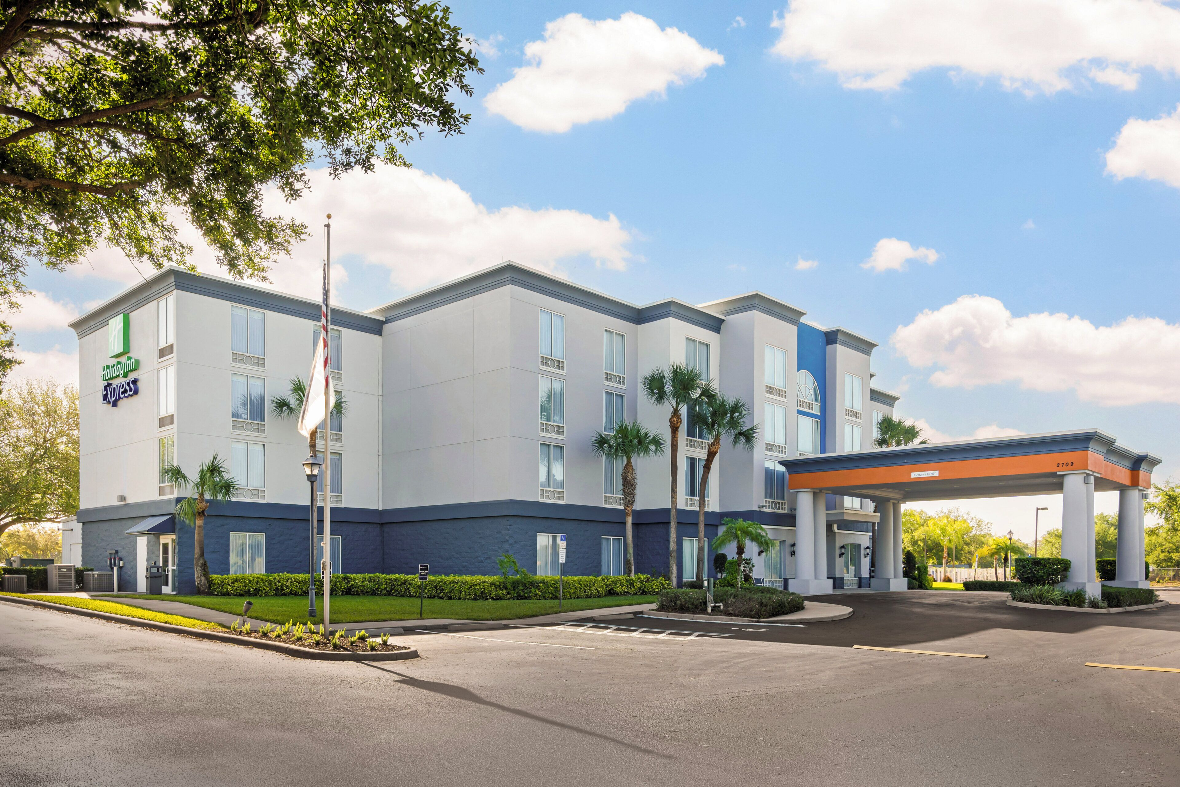 Un hotel Holiday Inn Express con entrada techada y estacionamiento.