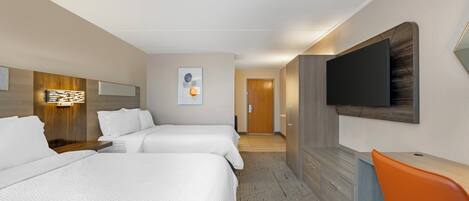 A hotel room with two beds, a desk, a TV, and a bathroom in the background.