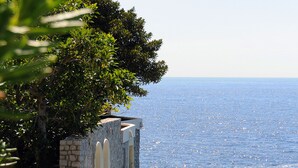 A stone building with a balcony overlooking the sea. - Hôtel Cap-Estel (Èze)