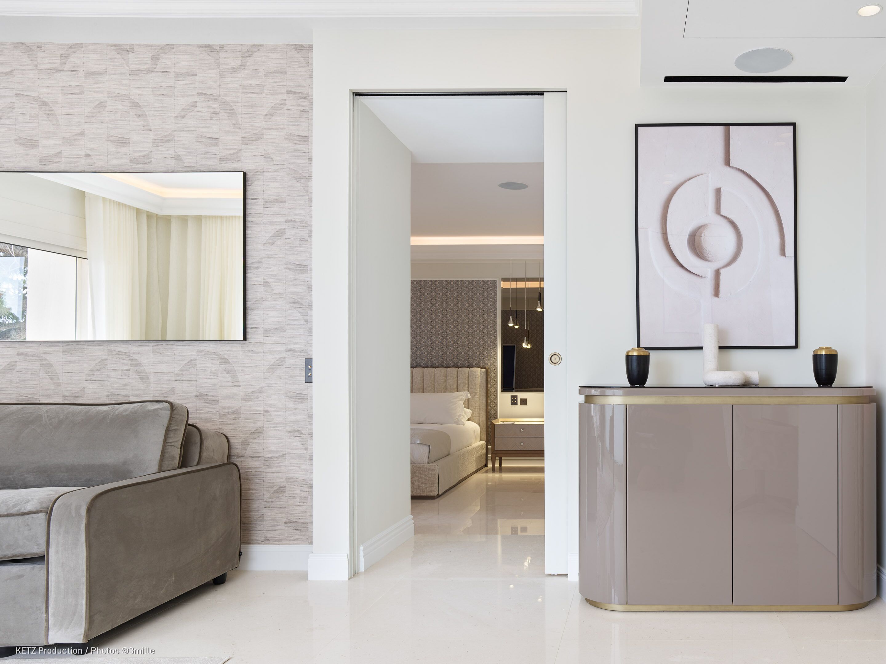 A modern living room with a sofa, a cabinet, and a large abstract painting.