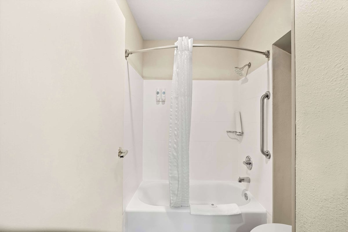 A bathroom with a shower, a bathtub, and a toilet.