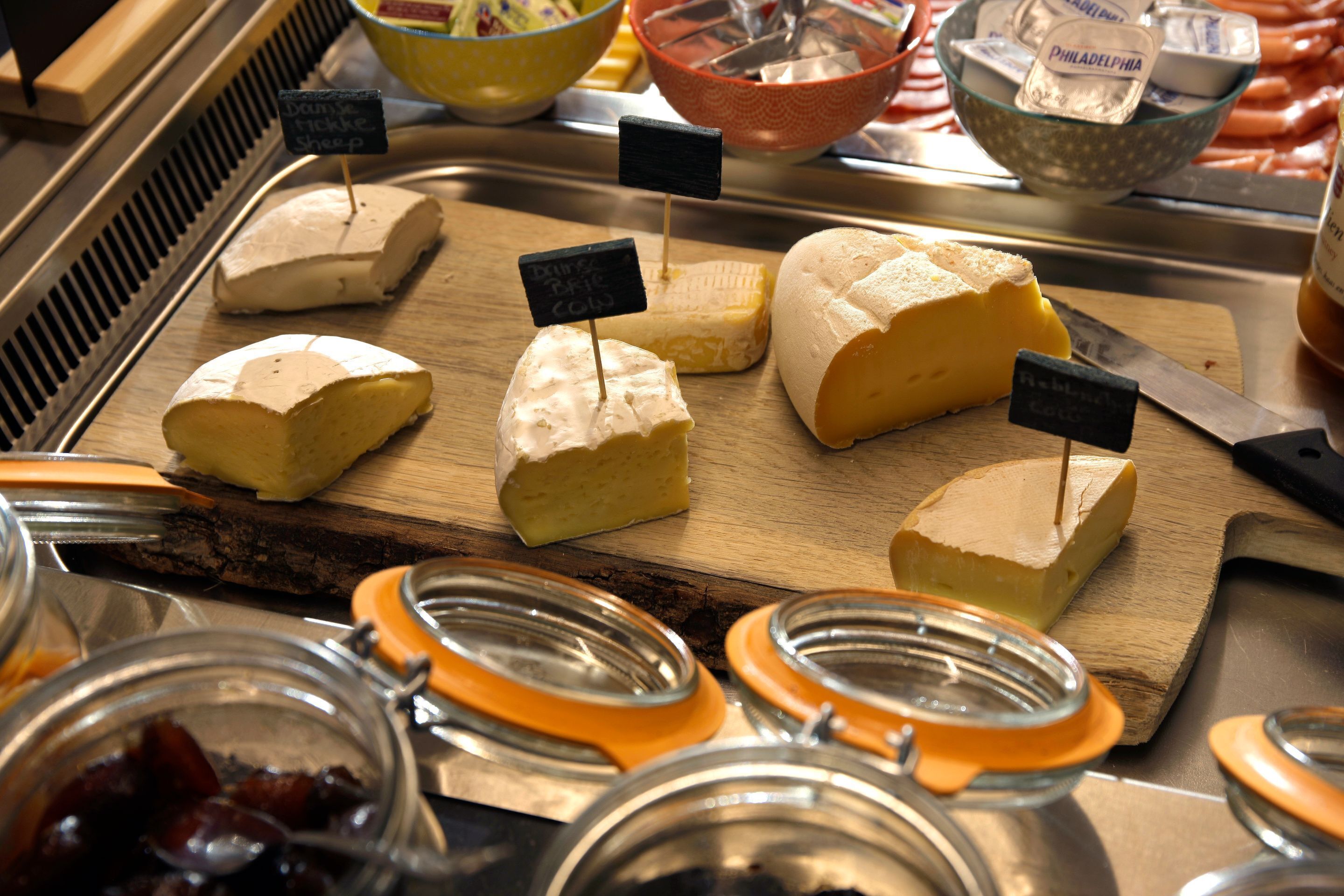 A display of various cheeses with labels indicating their type and origin.