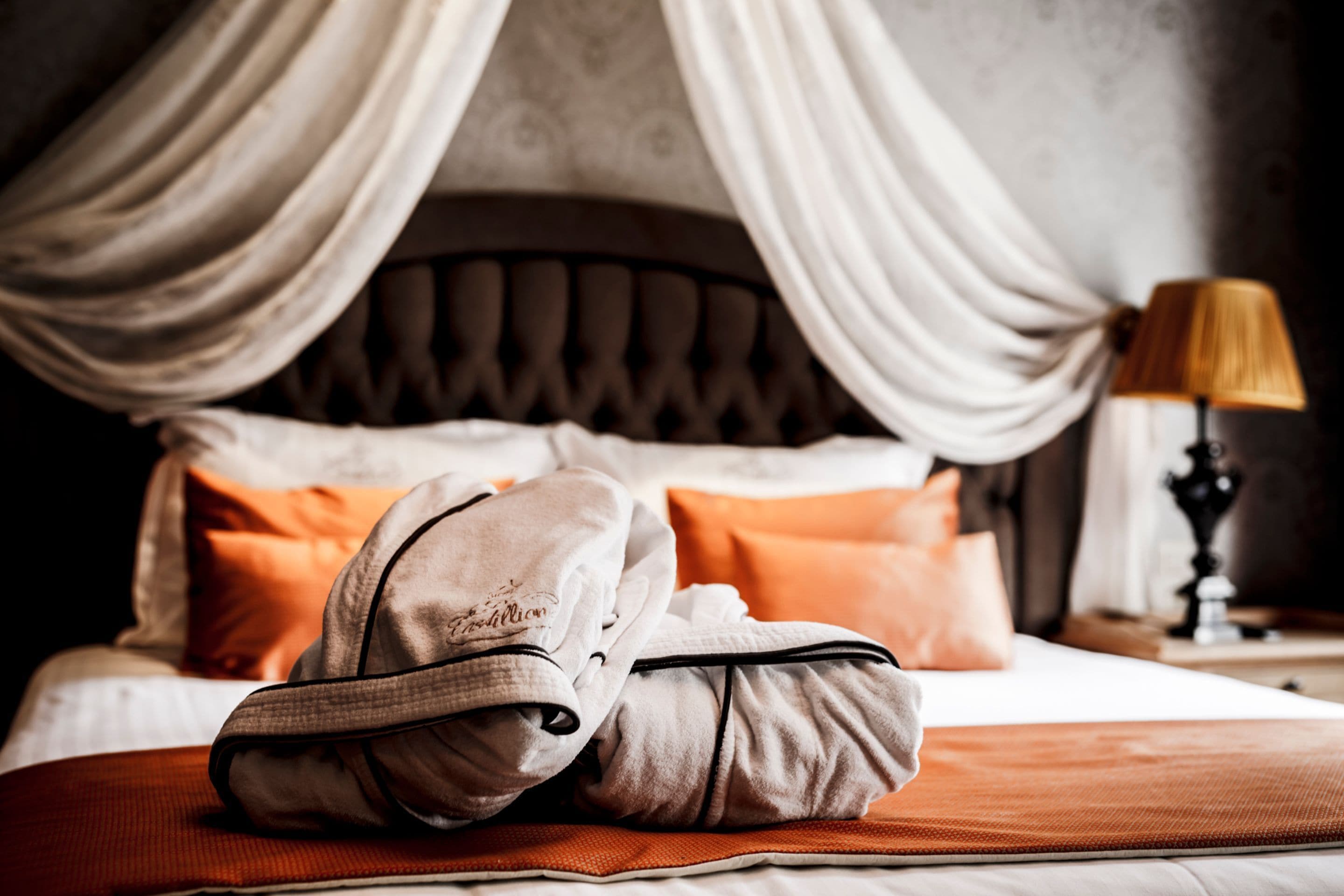 A neatly made bed with a headboard, pillows, and a blanket.