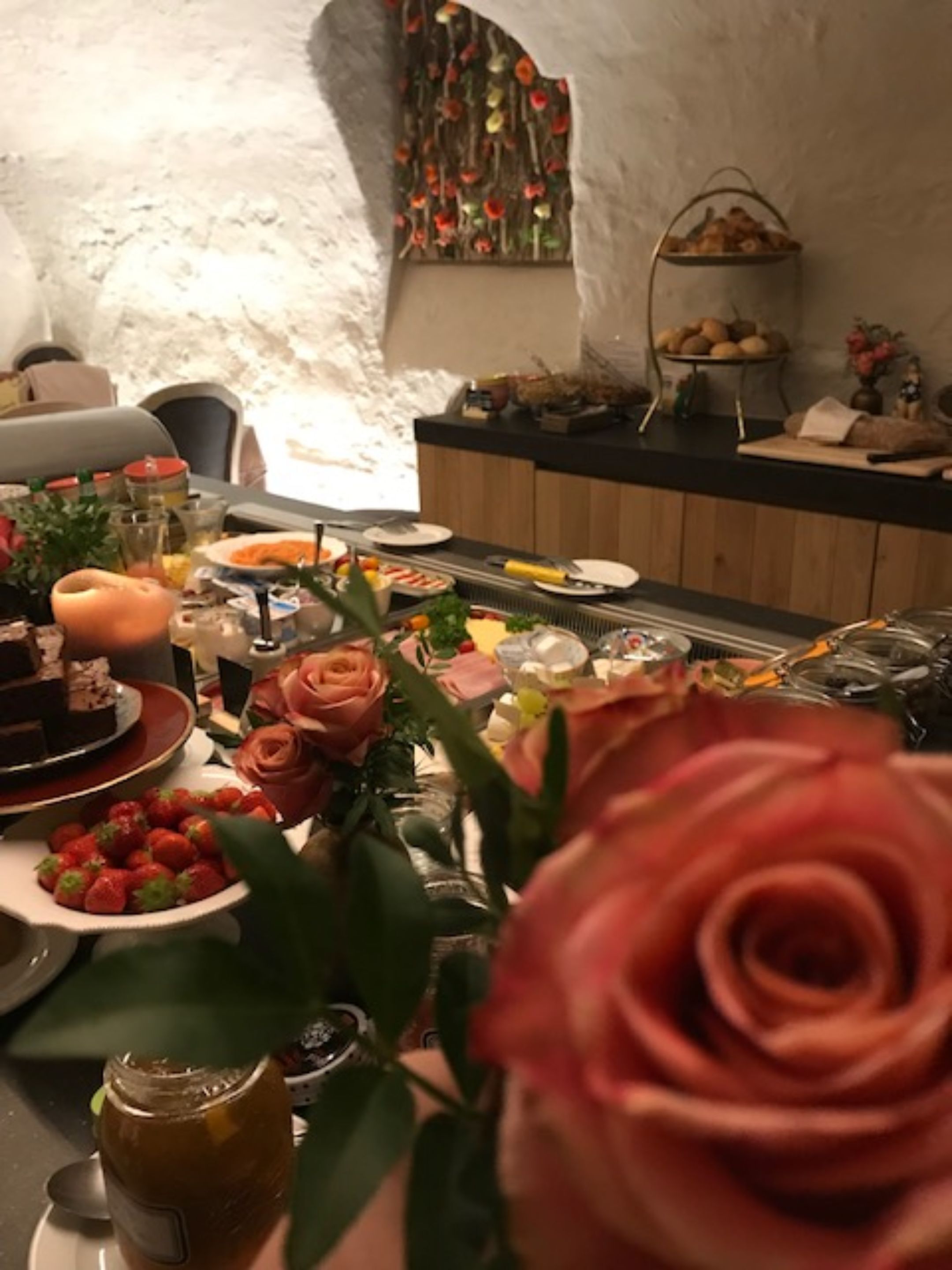 A dining area with a buffet setup, including various food items and a decorative wall.