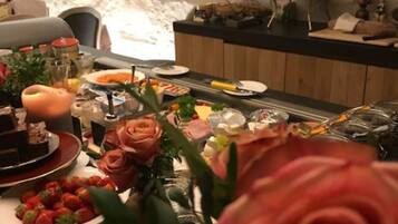A dining area with a buffet setup, including various food items and a decorative wall.