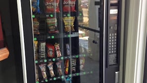 A vending machine with snacks like Doritos and Snickers.