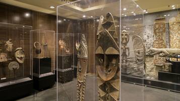 Una exposición de museo con diversos artefactos culturales exhibidos en vitrinas.