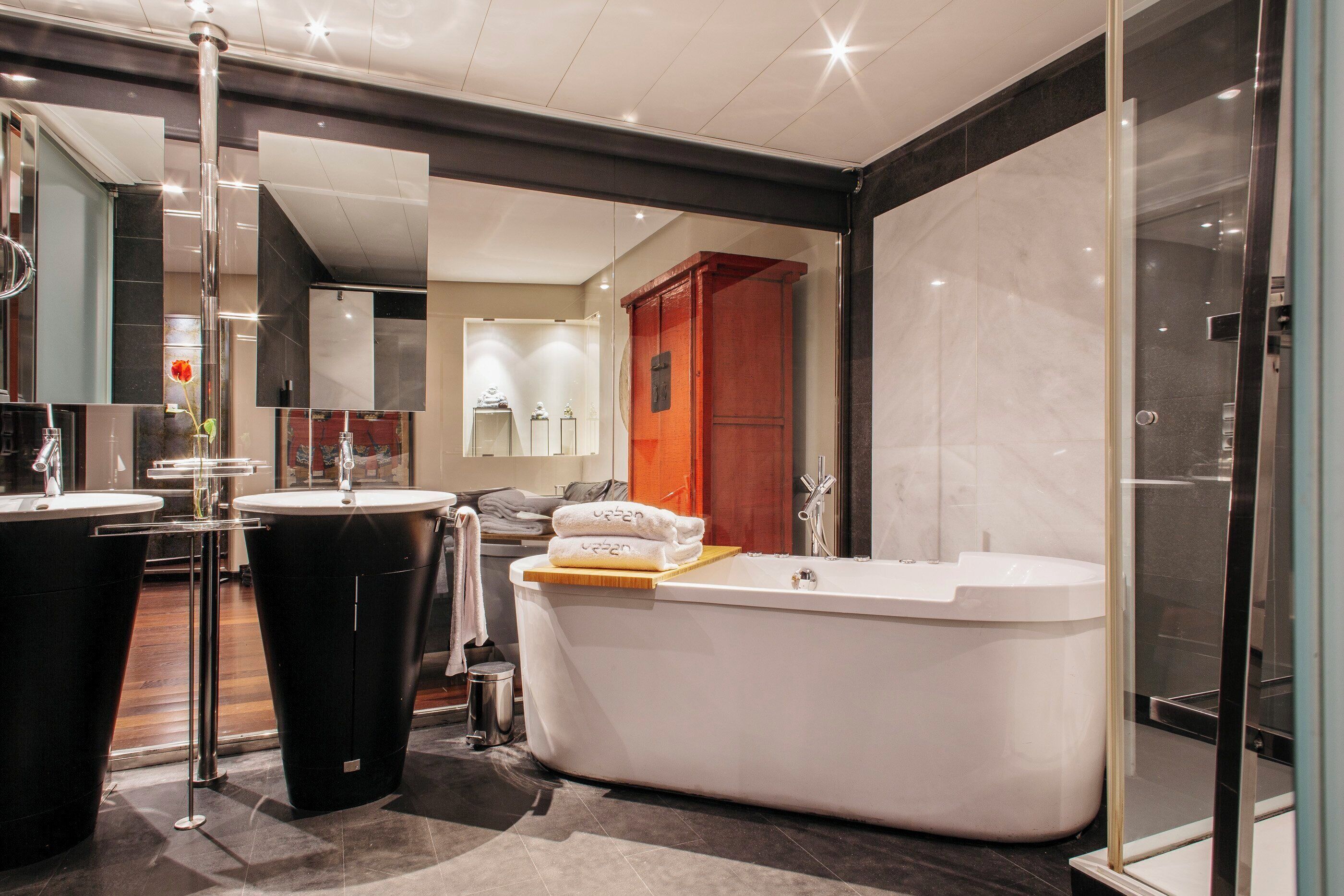 A modern bathroom with a freestanding bathtub, a separate sink, and a glass shower enclosure.
