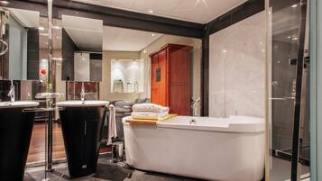A modern bathroom with a freestanding bathtub, a separate sink, and a glass shower enclosure.