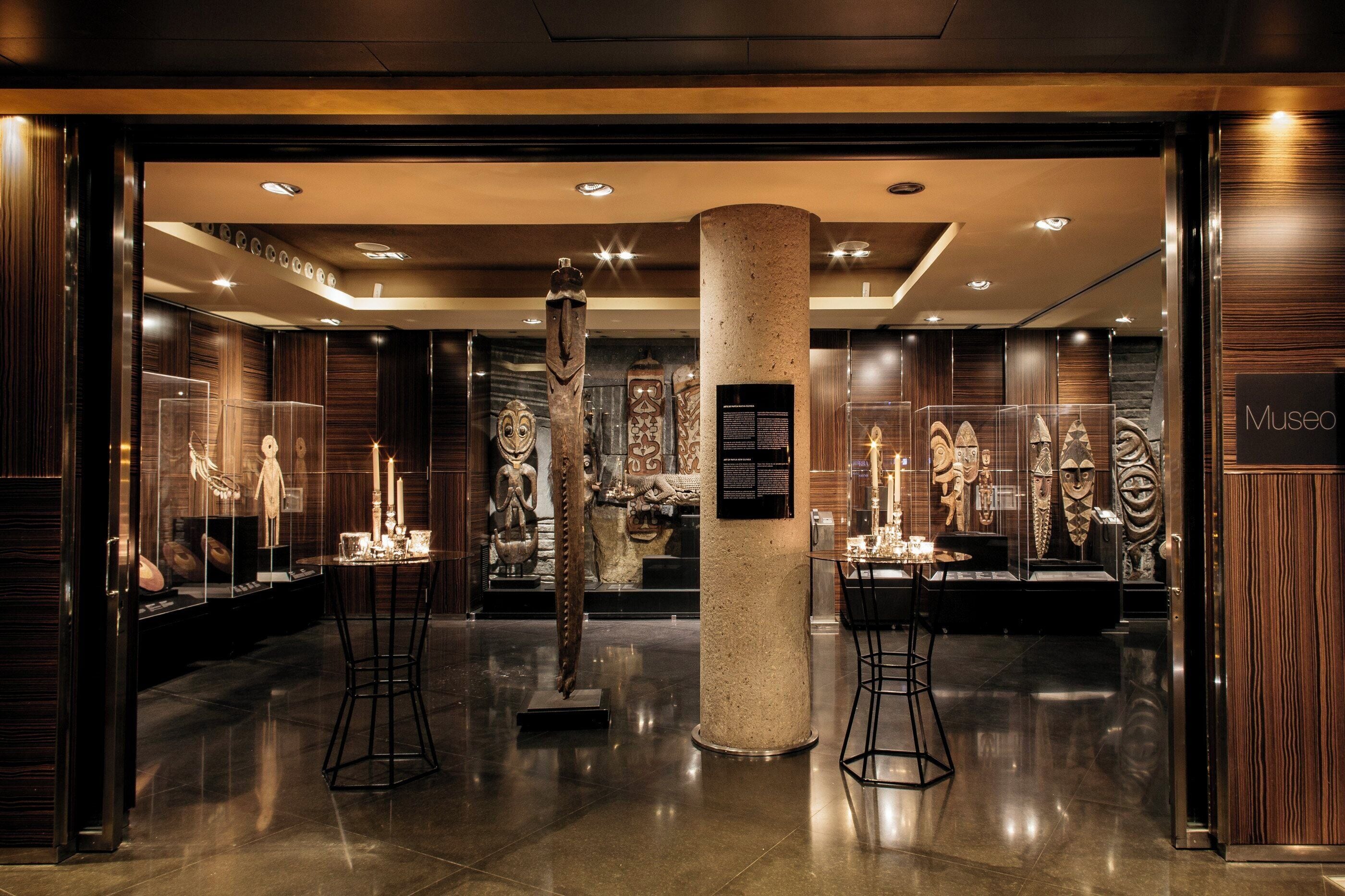 A museum interior with glass display cases, a central pillar, and a polished floor.