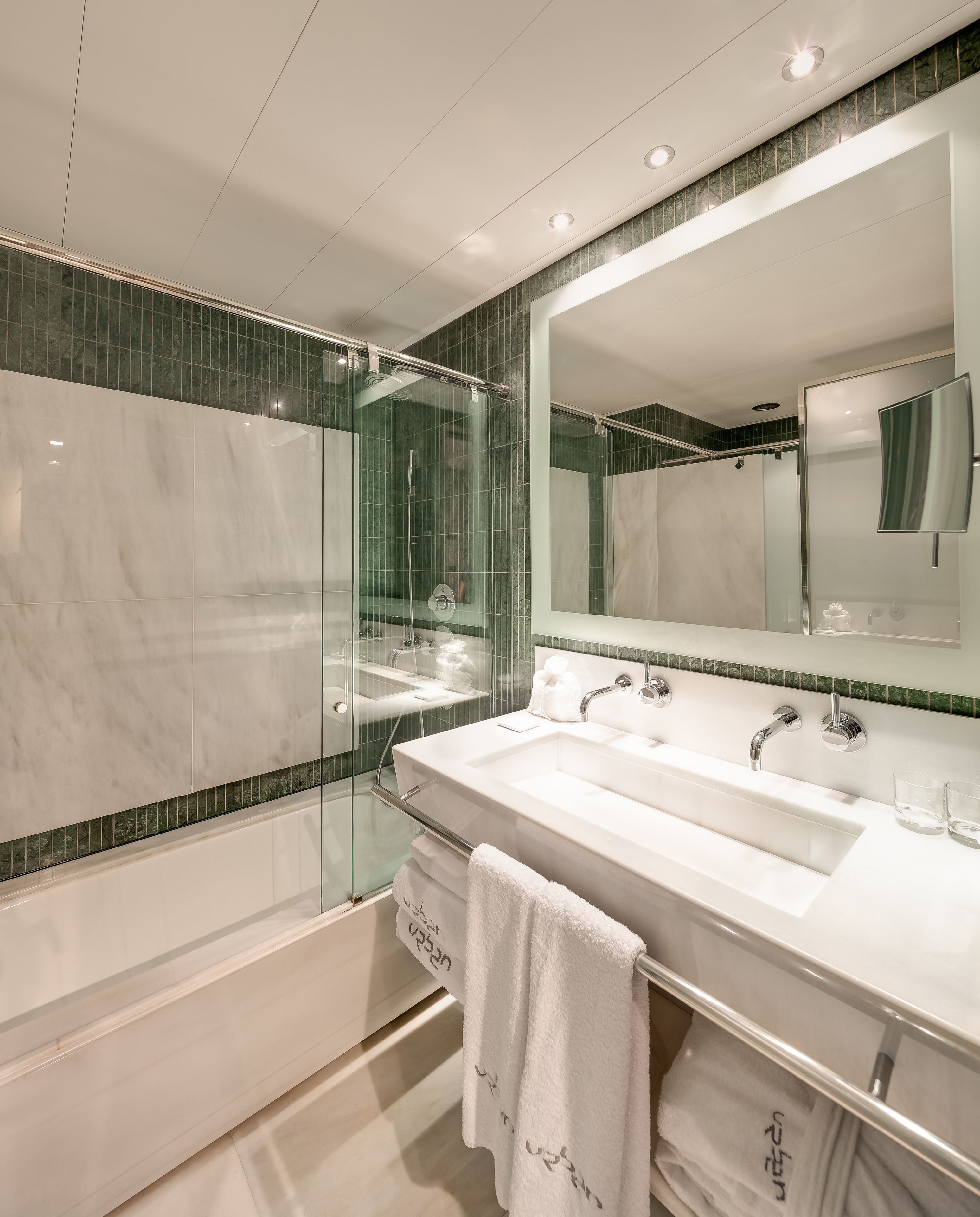 A modern bathroom with a glass-enclosed shower, a double sink vanity, and a large mirror.