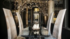 A modern interior with a glass table, white chairs, and decorative branches with lights. - Hotel Urban, a Small Luxury Hotel of the World  (Madrid)