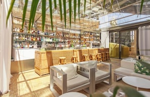 A modern bar area with a variety of liquor bottles, wooden furniture, and a glass ceiling. - Hotel Urban a Small Luxury Hotel of the World  (Madrid)