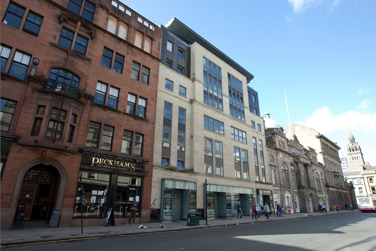 A row of multi-story buildings with various storefronts, including a Peckham's restaurant.