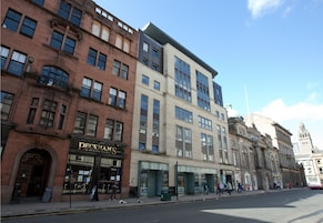 A row of multi-story buildings with various storefronts, including a Peckham's restaurant.