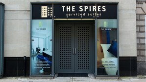 A hotel entrance with a sign reading "The Spires serviced suites" and a large glass door. - The Spires Serviced Apartments Glasgow (Glasgow)