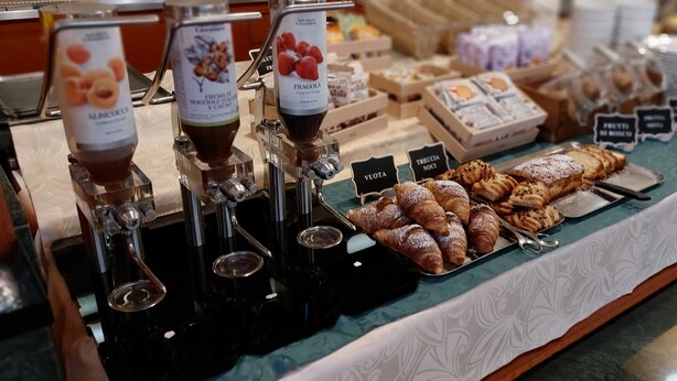 A buffet with various food items and drink dispensers.