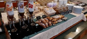 Buffet com diversos alimentos e dispensadores de bebidas.