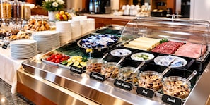 Een buffet met diverse gerechten, zoals fruit, noten en vlees.