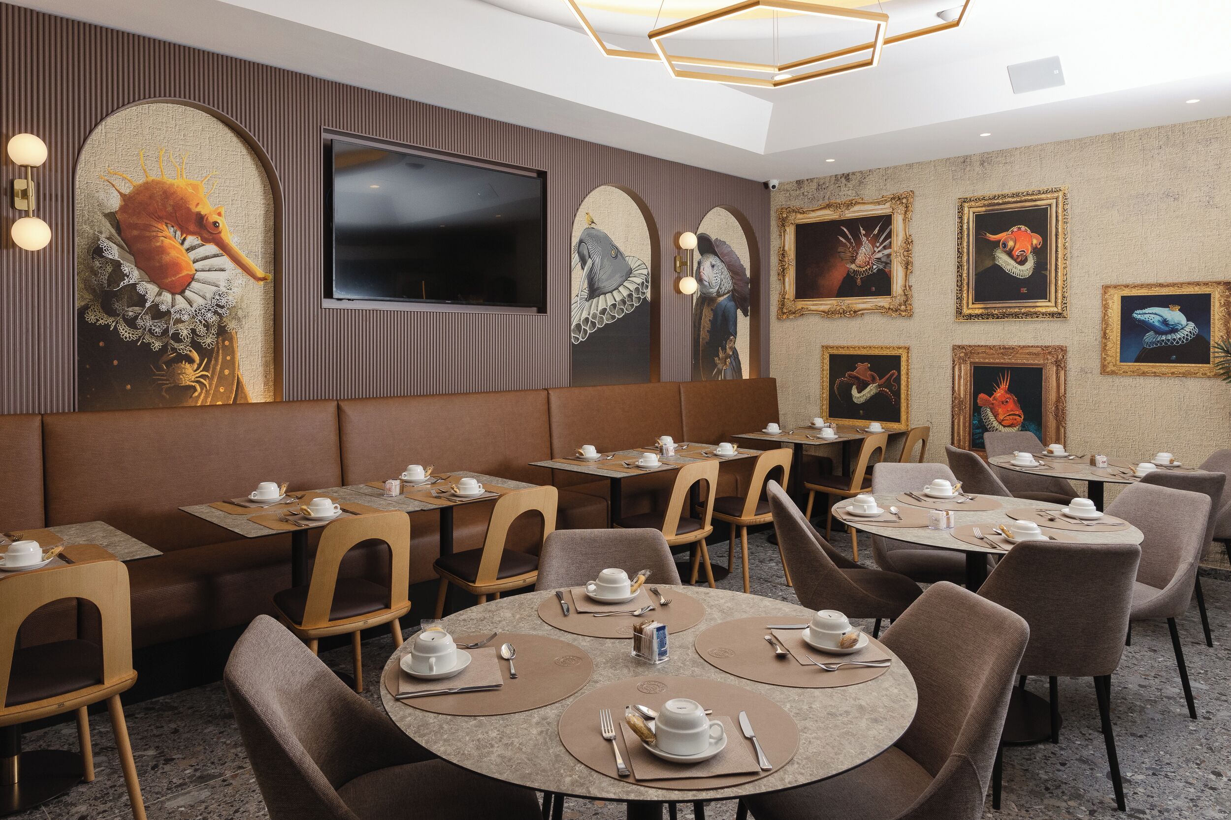 Ein Restaurant mit runden Tischen, braunen Stühlen und einer hohen Decke mit einer geometrischen Leuchte.