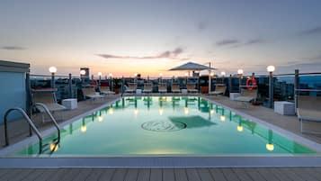 Una piscina al aire libre de temporada, sillones reclinables de piscina