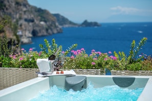 A hot tub with a view of the sea and flowers. - Hotel Onda Verde (Praiano)