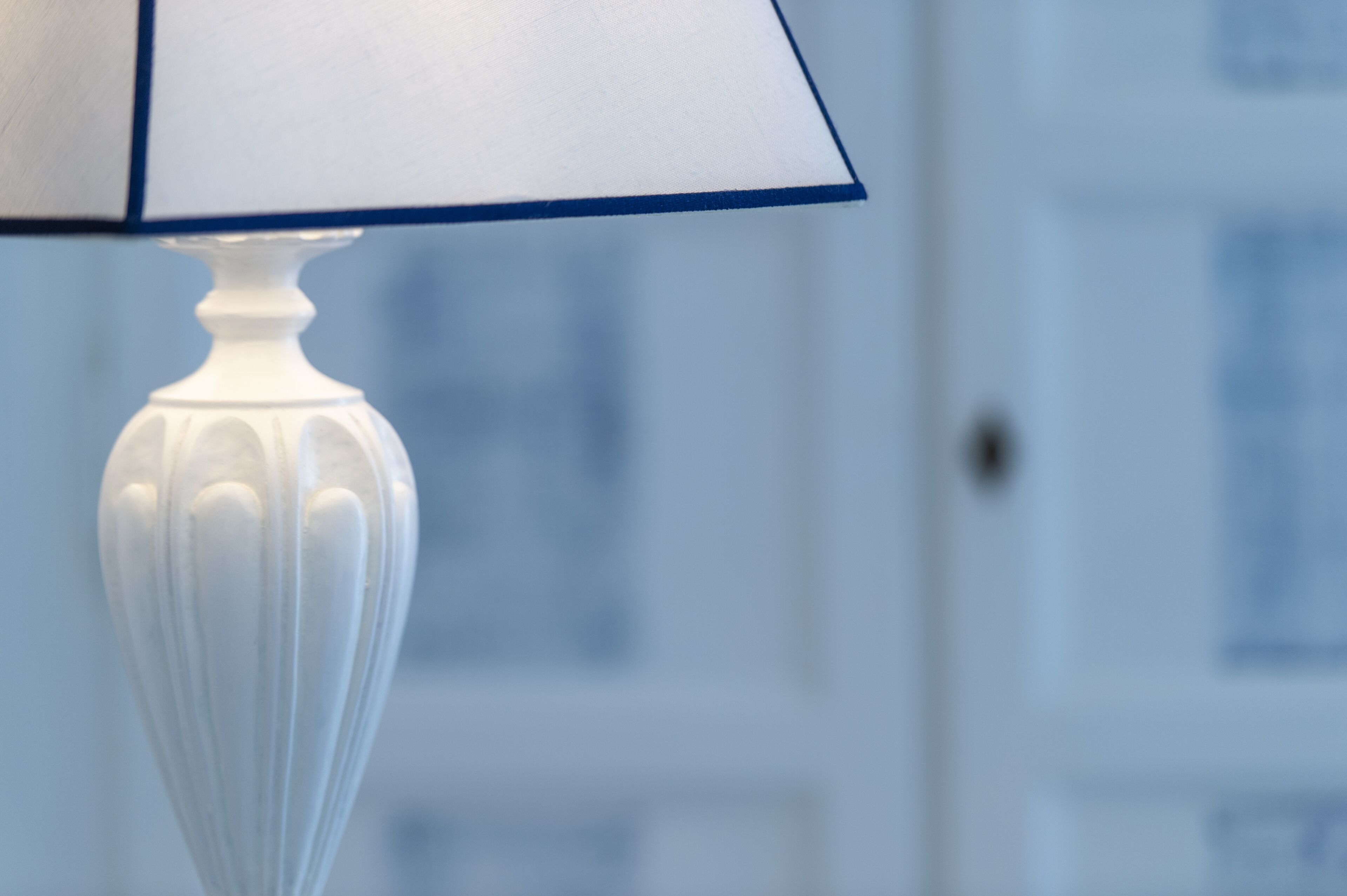 A white table lamp with a blue shade.