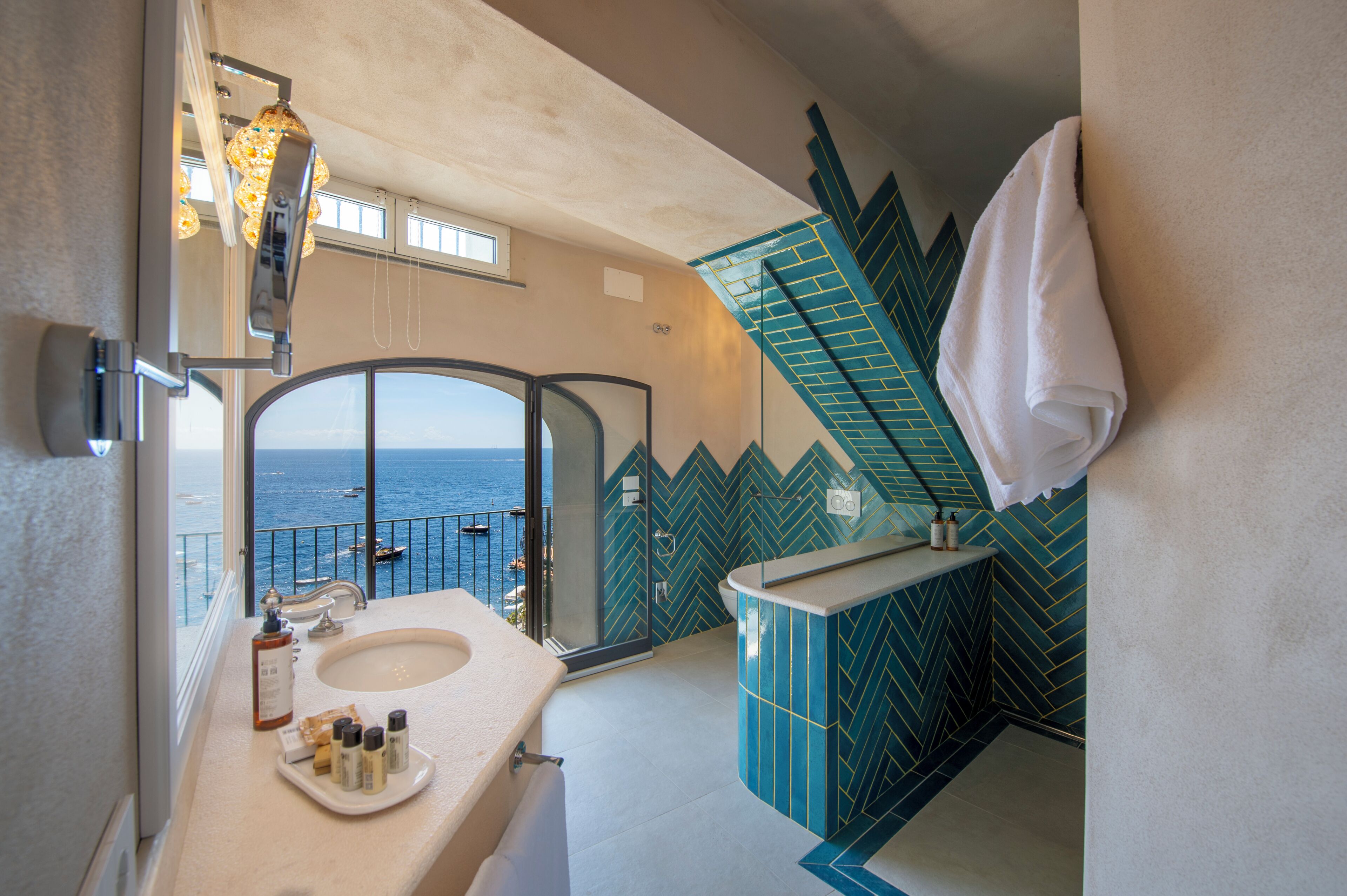 A bathroom with a large window, a sink, and a mirror.
