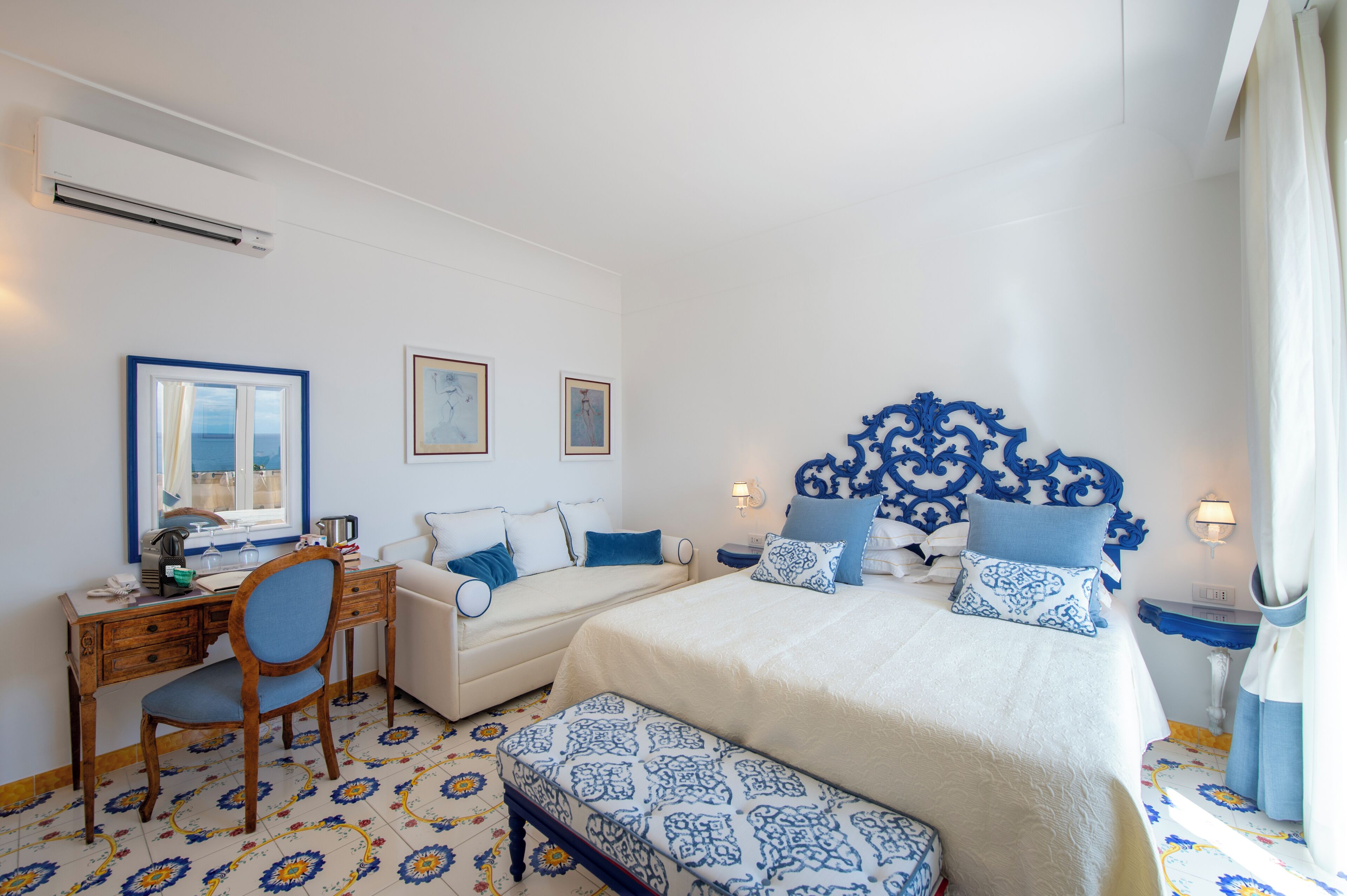 A bedroom with a bed, a desk, a chair, and a window.