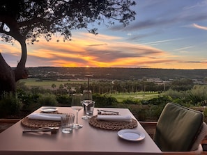 A table set for two with a view of a sunset over a landscape. - Rotana la Reserva (Manacor)