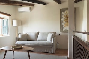 A room with a sofa, a lamp, and a painting on the wall. - Rotana la Reserva (Manacor)