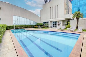 Alberca al aire libre y camastros 