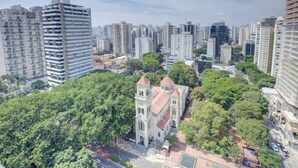 A cityscape with high-rise buildings, a church with two towers, and surrounding greenery. - Comfort Hotel Ibirapuera (São Paulo)