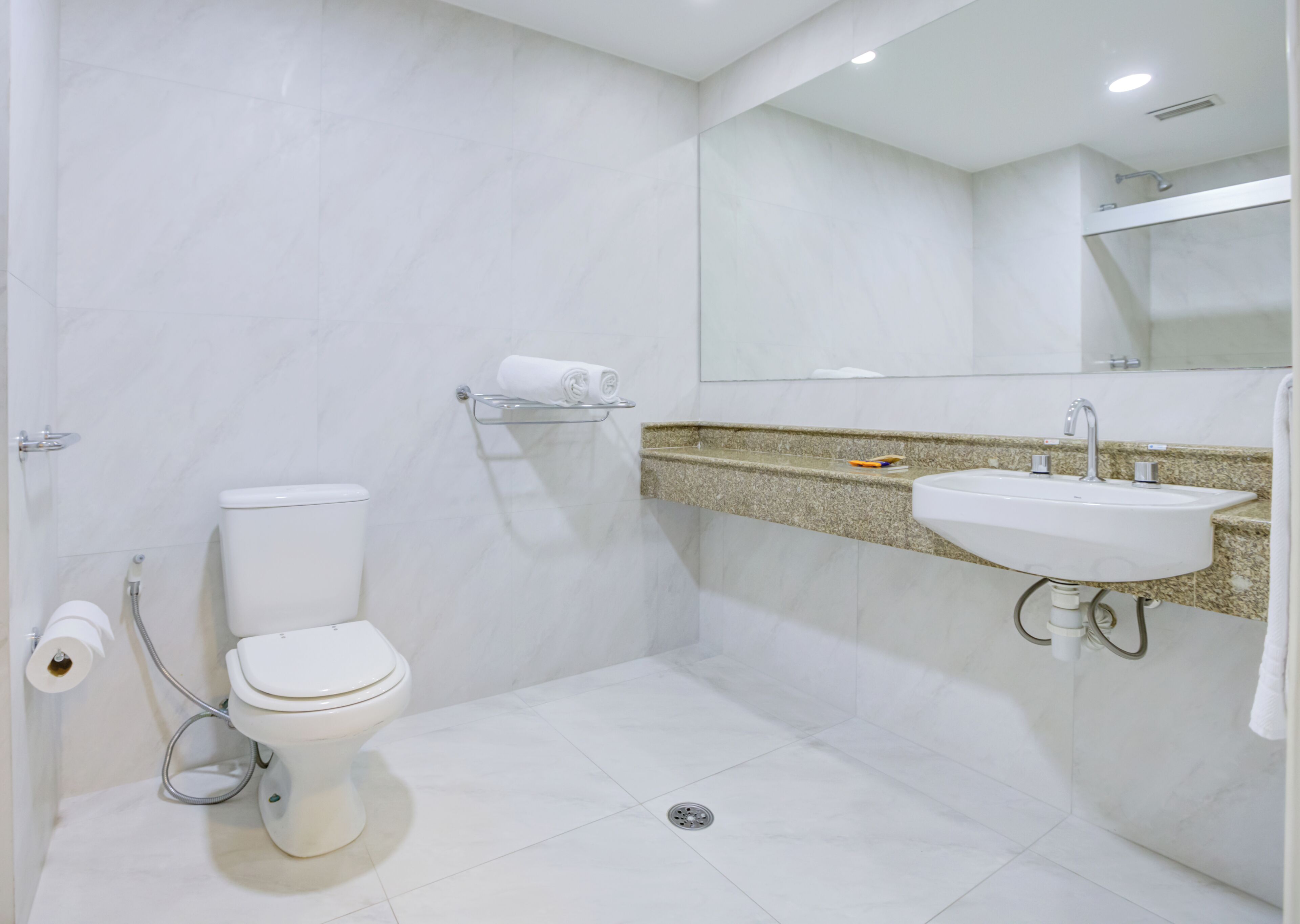 Un baño moderno con inodoro, lavabo y ducha.