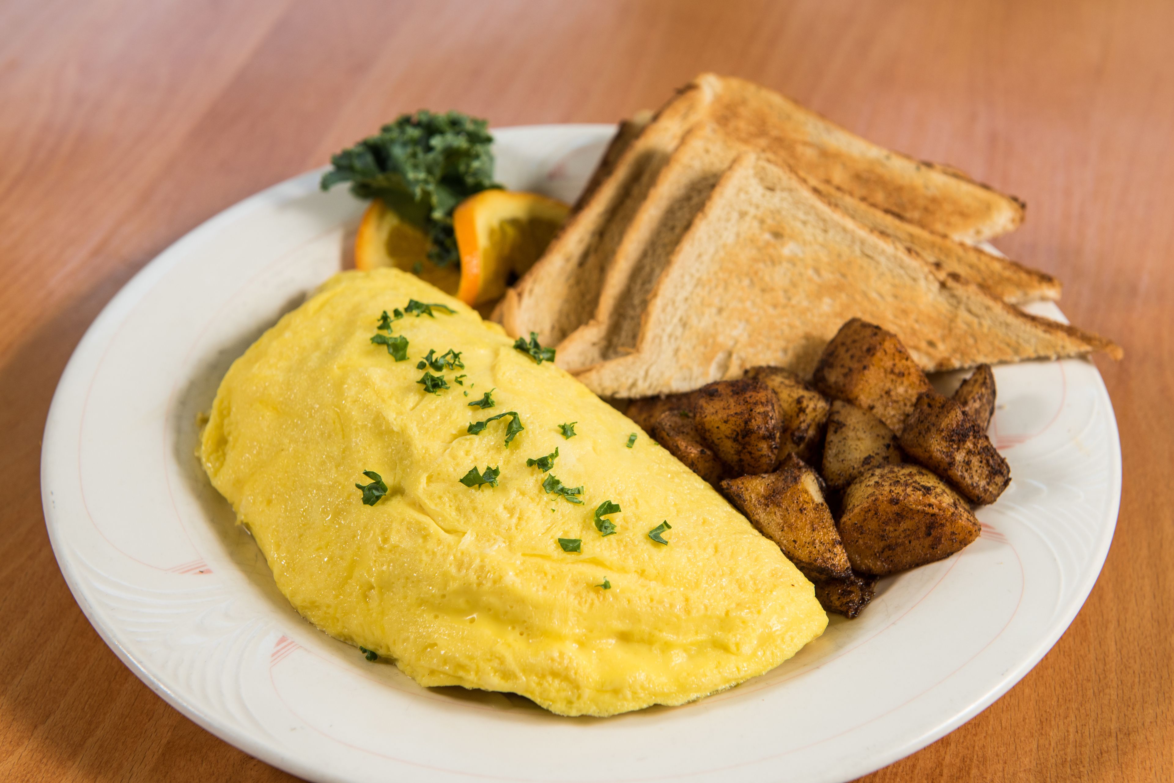 A plate with scrambled eggs, toast, and roasted potatoes.