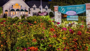A hotel sign with a garden in front.