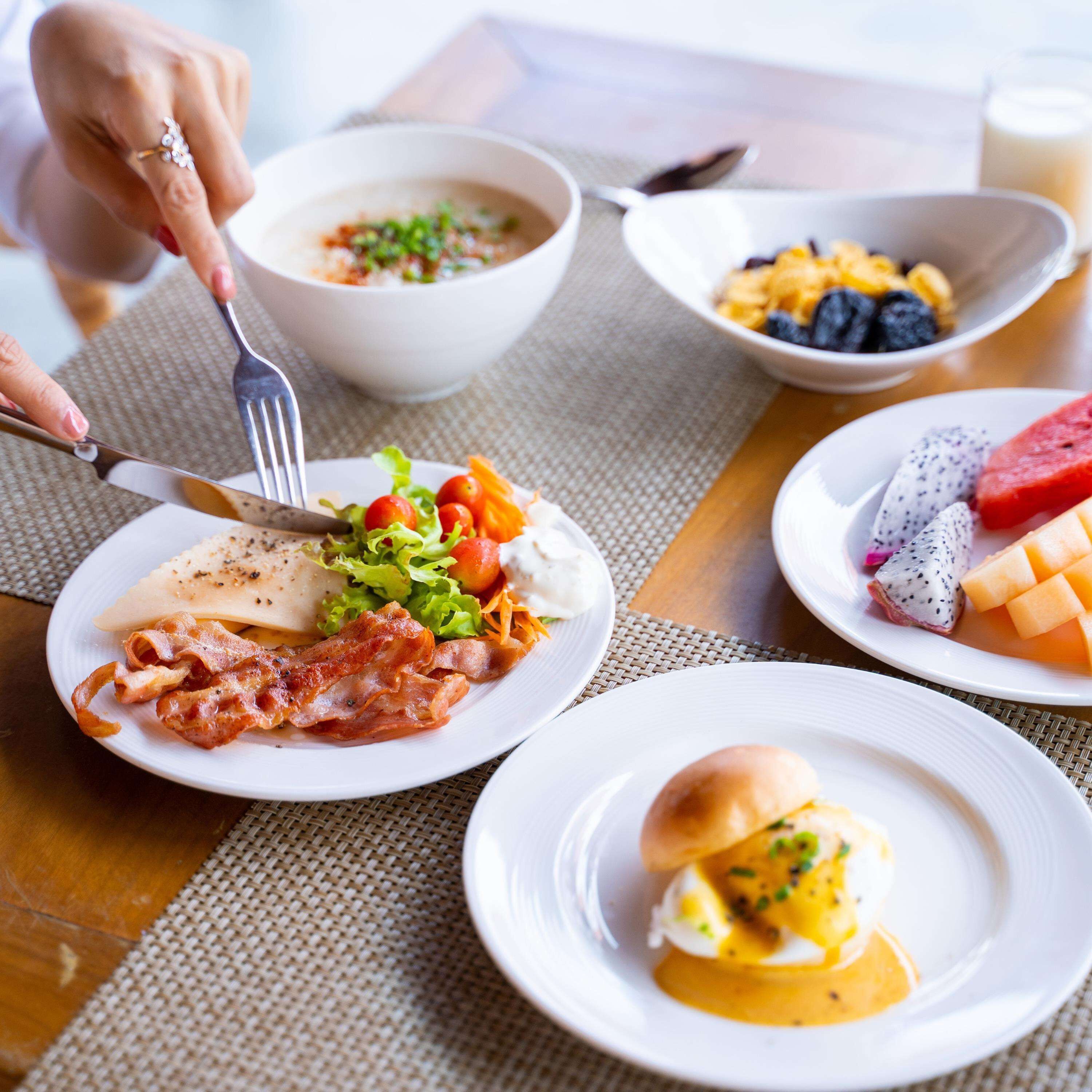 A breakfast setting with various dishes including eggs, bacon, and fruit.