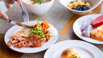 A breakfast setting with various dishes including eggs, bacon, and fruit.