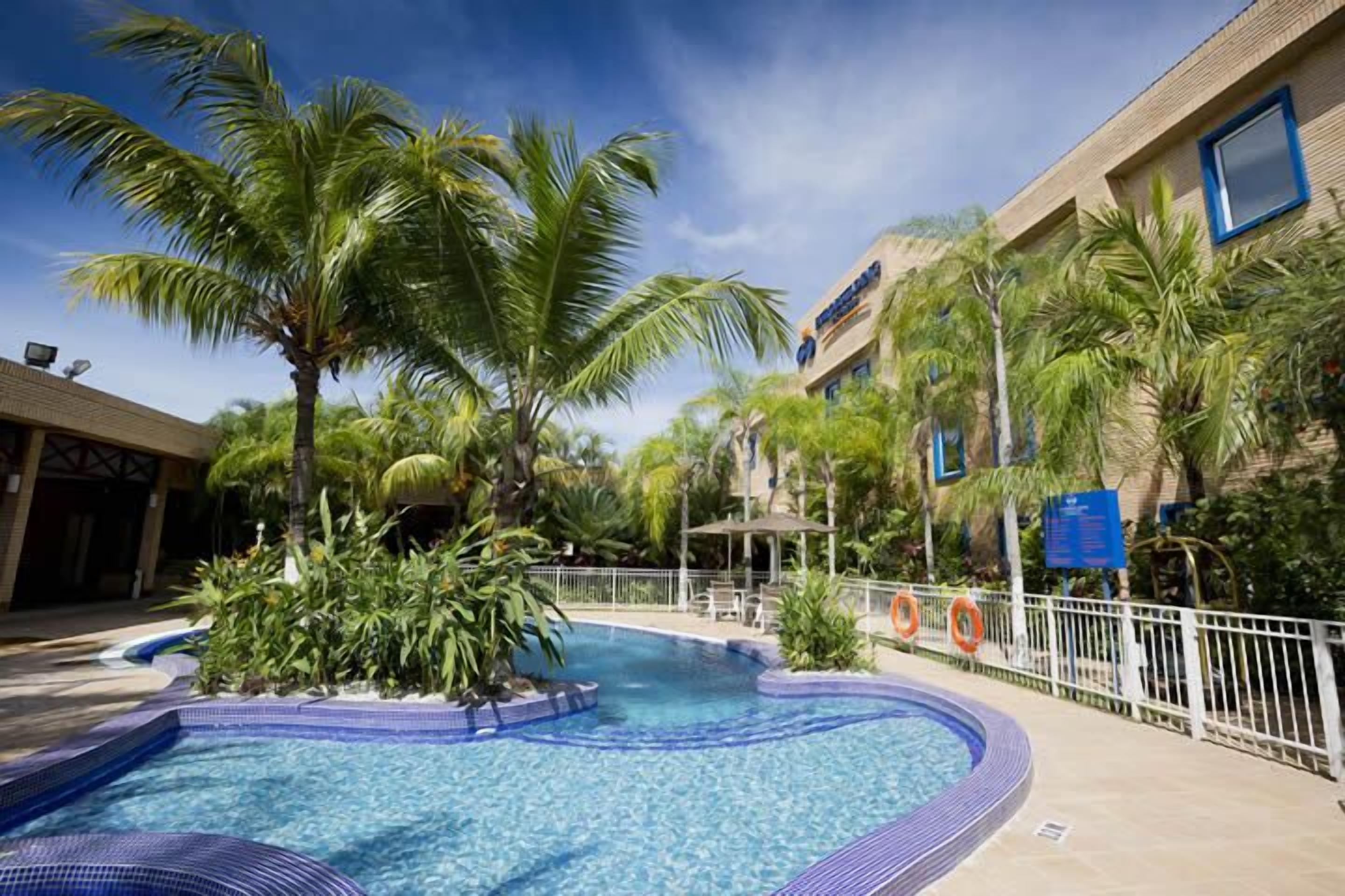 Una piscina al aire libre, sombrillas