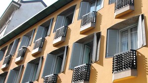 La façade d’un hôtel ornée de nombreux balcons, chacun présentant un motif géométrique unique.