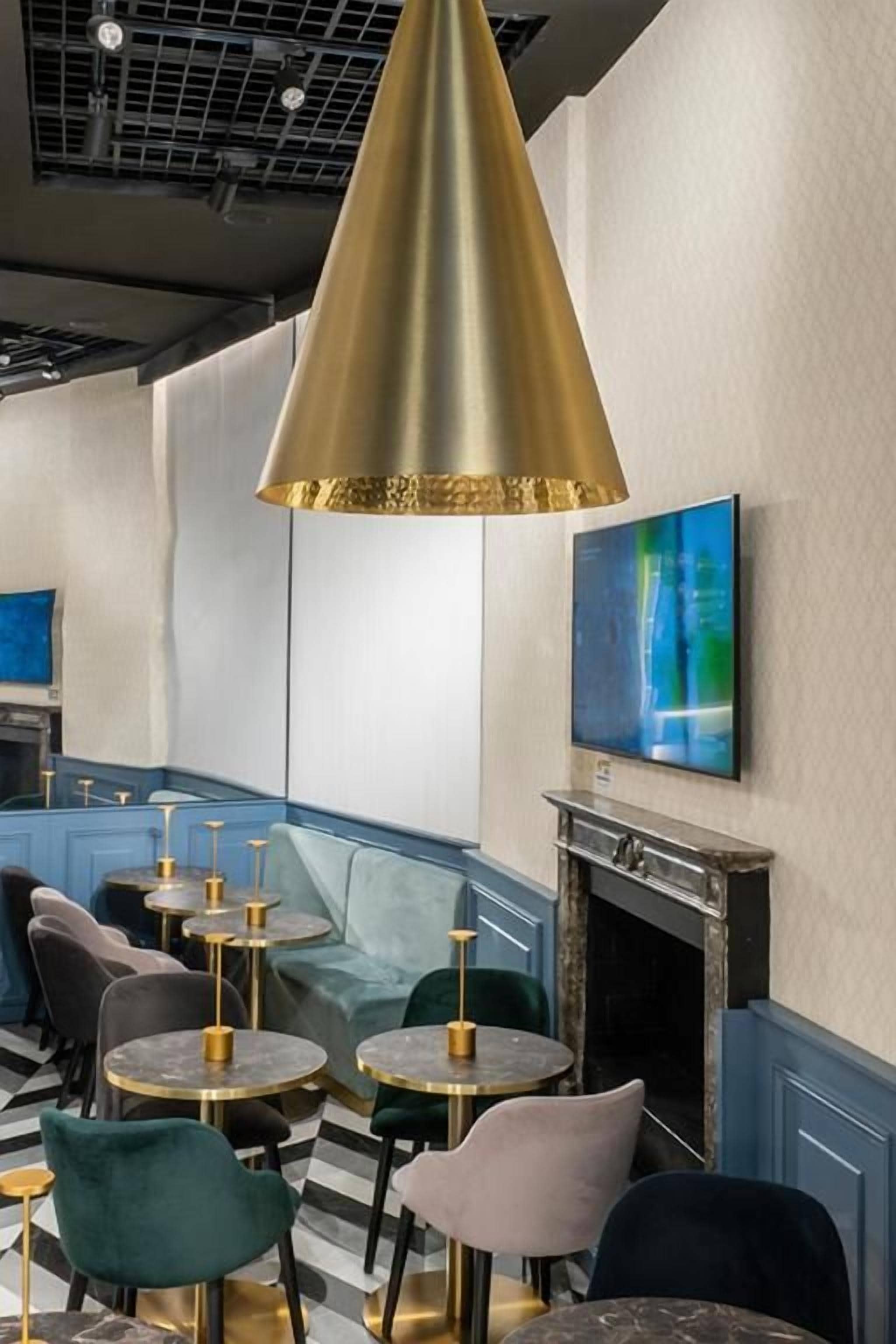 Un intérieur moderne avec des tables et des chaises rondes, une cheminée et un grand tableau au mur.