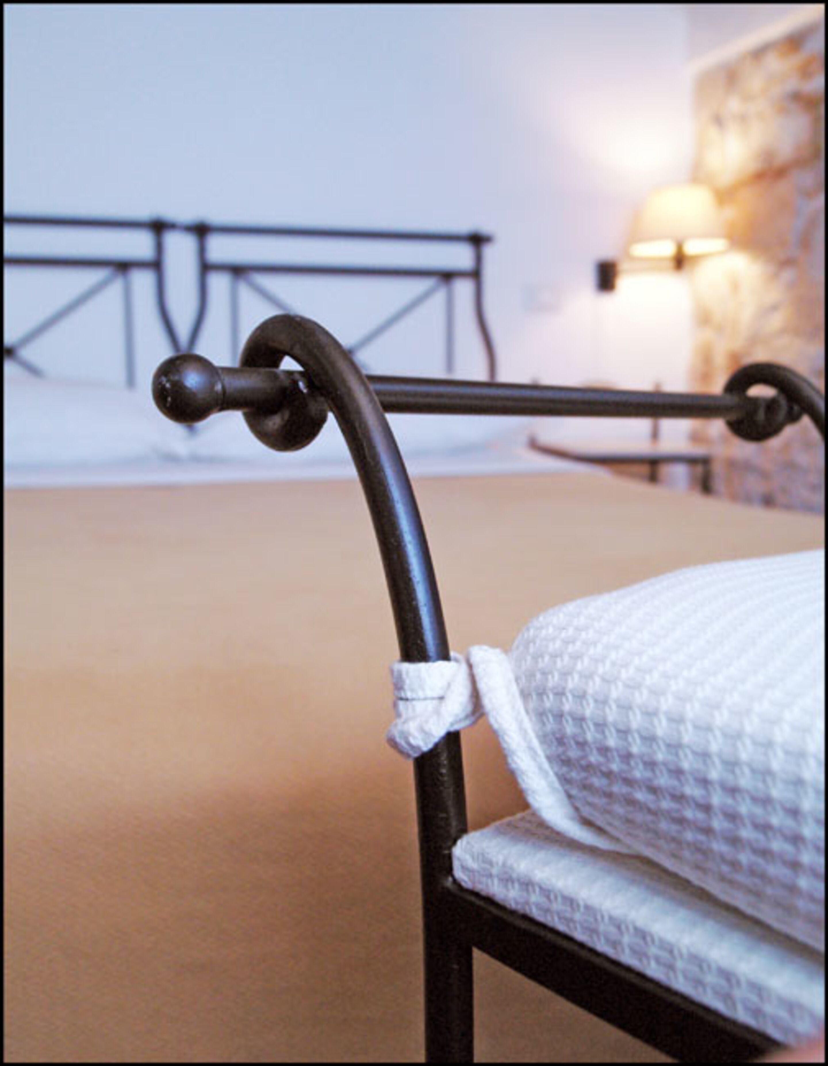Una cama con estructura metálica y colchón blanco.