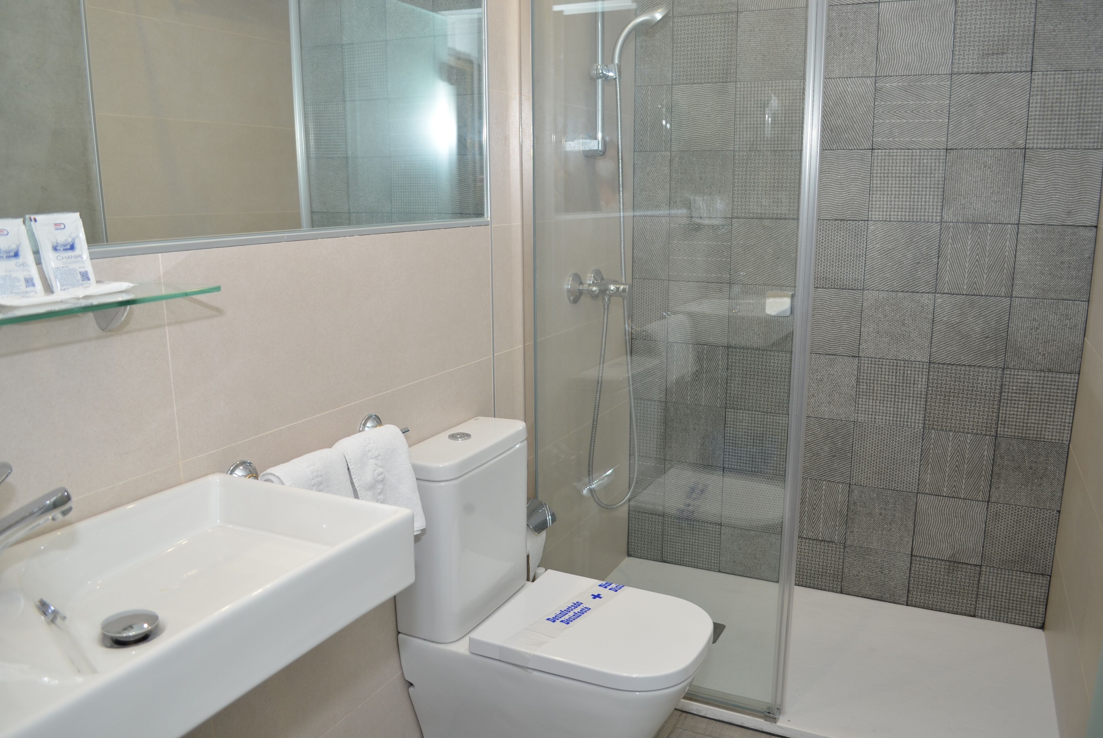 A bathroom with a white sink, toilet, and shower.