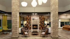 A modern lobby with a fireplace, seating area, and decorative lighting. - Hilton Garden Inn Kitchener/Cambridge (Cambridge)