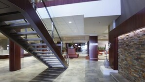 Un hall d’entrée spacieux, doté d’un escalier moderne, d’un mur en pierre et d’un espace détente.