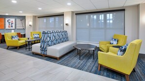 A modern lobby with yellow armchairs, a sofa, and a small table. - Holiday Inn Express Casper-Interstate 25 by IHG (Casper)
