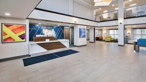 A spacious lobby with a reception desk, seating area, and artwork on the walls. - Holiday Inn Express Casper-Interstate 25 by IHG (Casper)