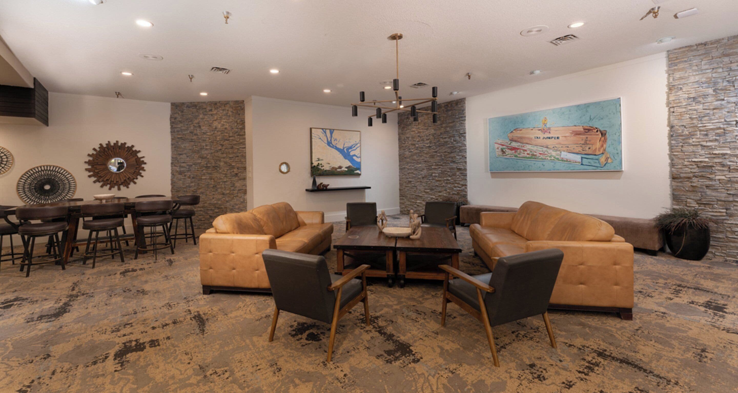 A modern living room with leather sofas, a coffee table, and a dining area with chairs and a table.