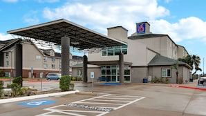 A hotel entrance with a covered walkway, a handicap parking sign, and a fire lane. - Motel 6 Pharr, TX (Pharr)