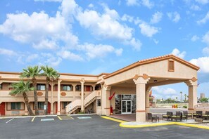 A hotel with a covered entrance, palm trees, and a parking lot. - Super 8 by Wyndham Phoenix Downtown (Phoenix)
